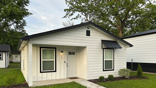 A single-story house with a front door, two windows, a small porch, and a paved driveway. - The Relaxing House - Quiet 2 Bedroom Home (Raymond)