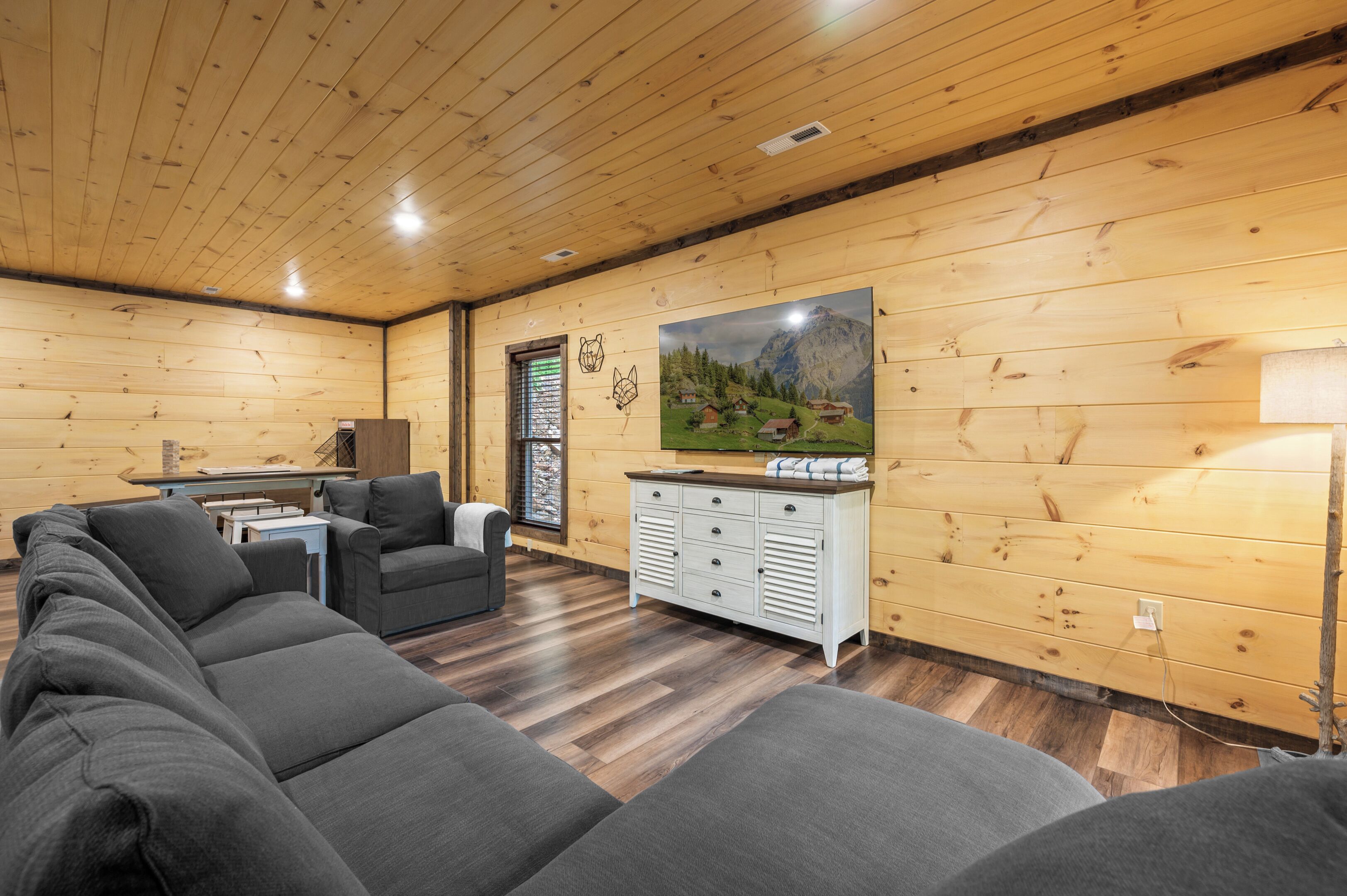 A cozy cabin interior with a wooden interior, a sofa, a small table, and a cabinet.