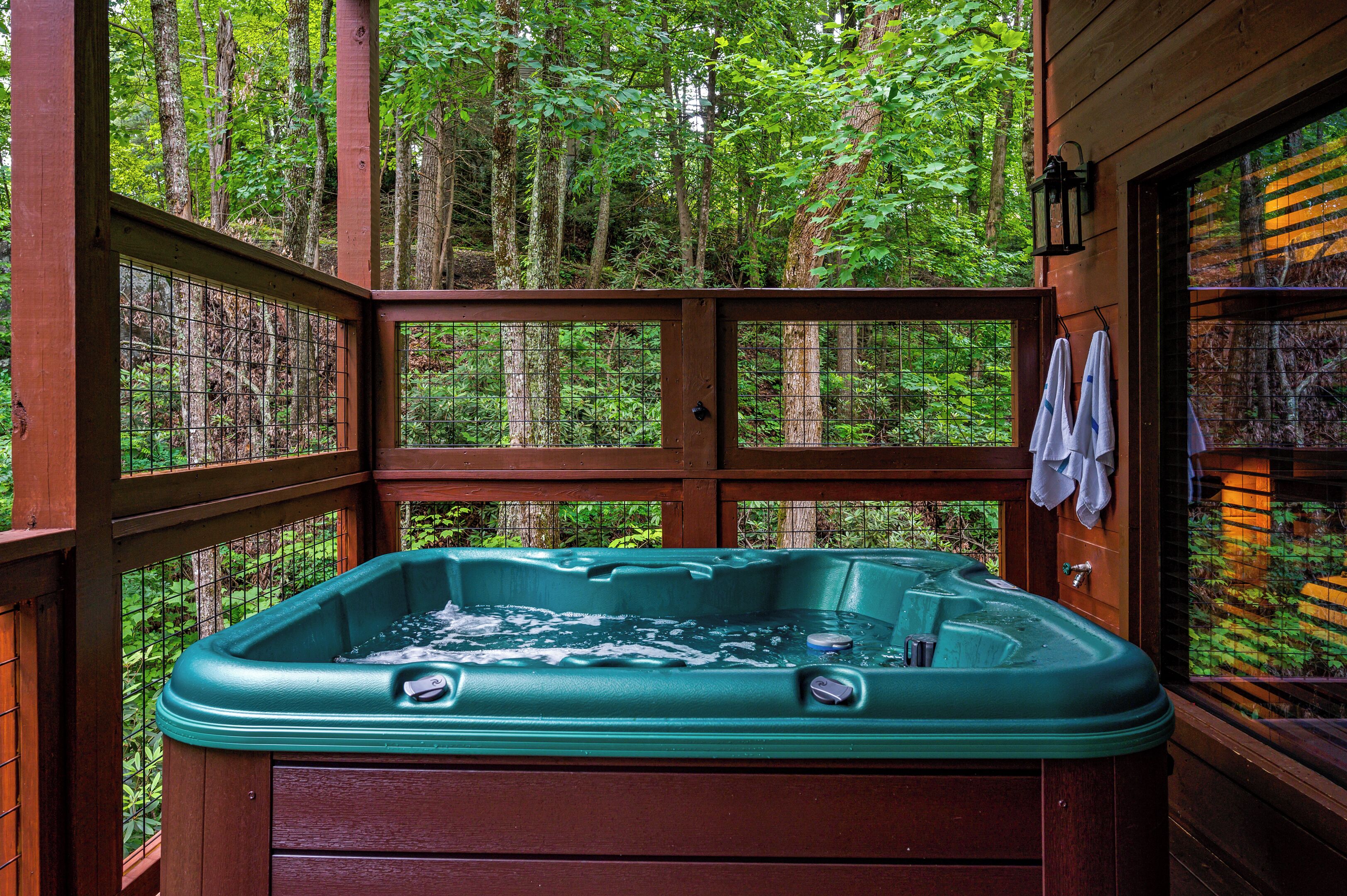 A hot tub in a wooden cabin surrounded by a forest.