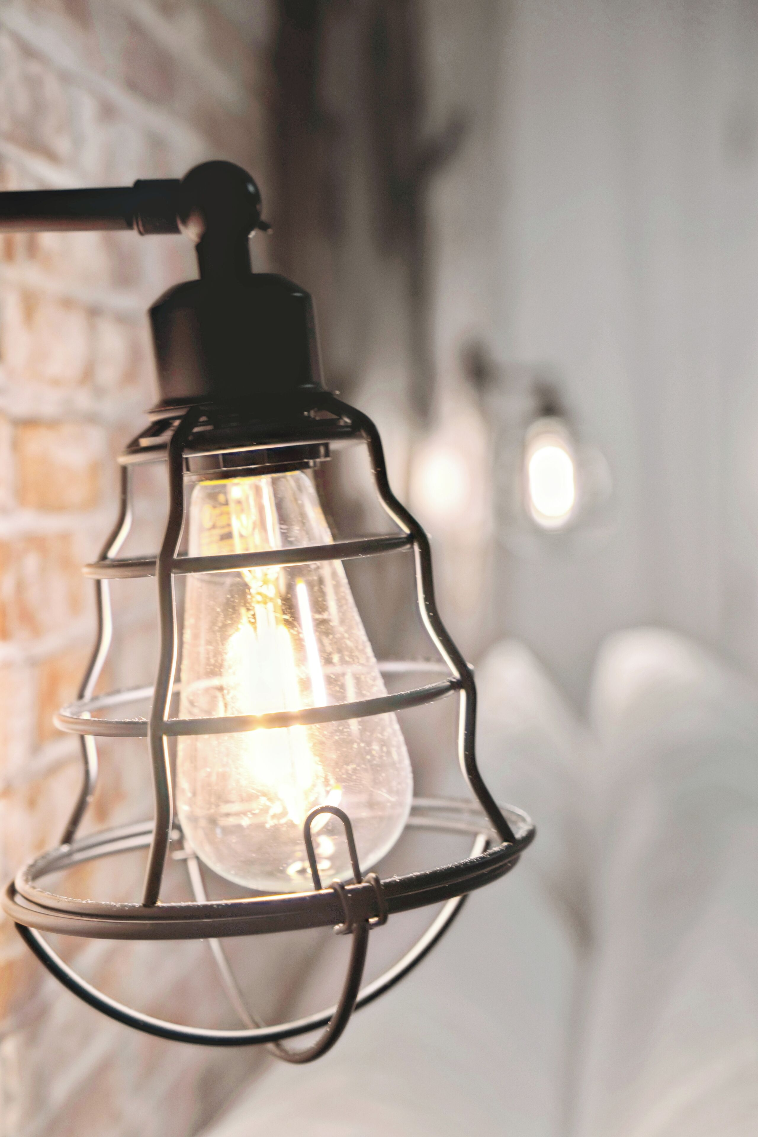 A close-up of a hanging industrial-style light fixture with a visible bulb.