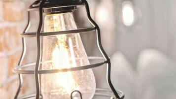 A close-up of a hanging industrial-style light fixture with a visible bulb.