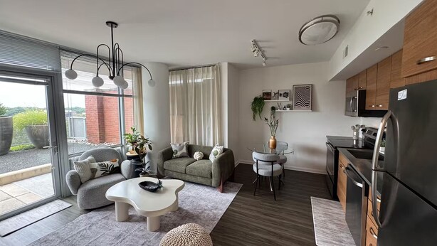 Eine moderne Küche mit Kühlschrank, Mikrowelle und einem Essbereich mit Tisch und Stühlen.