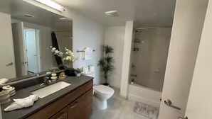 Ein modernes Badezimmer mit großem Spiegel, Waschbecken, Toilette und Dusche.