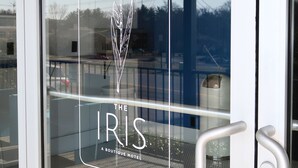 Een glazen deur met een logo en tekst die 'The Iris Boutique Hotel' aangeeft.
