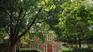 A stone building with a central entrance, surrounded by well-maintained lawns and trees. - Charming Suite in Music Row! (Nashville)