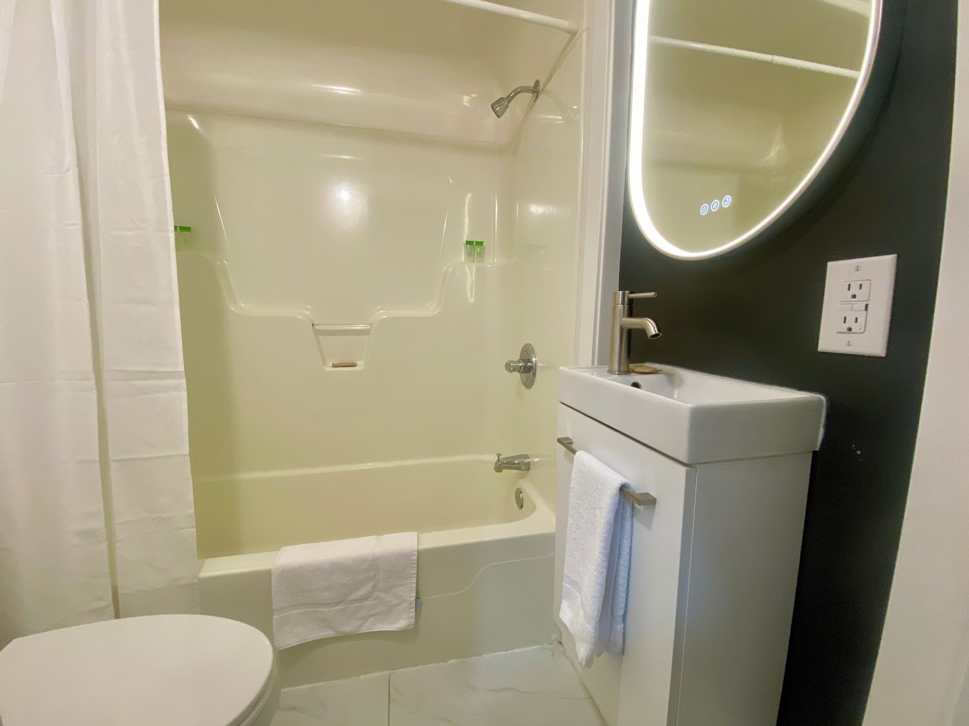 A modern bathroom with a bathtub, toilet, and sink.