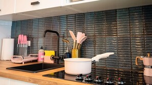A modern kitchen with a black backsplash, stainless steel appliances, and wooden countertops.