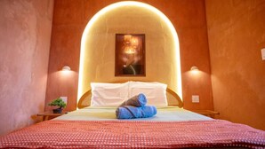 A hotel room with a bed, a small table with a plant, and two wall-mounted lamps. - Casa Lotus「UNIT 4「Limber」 (San Juan)