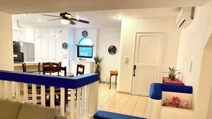 Una sala de estar con una escalera, un comedor y una cocina.