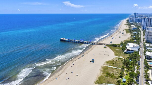 A coastal cityscape with a beach, a pier, and high-rise buildings. - Daisy Townhouse Villas Step from the beach (pompano beach)