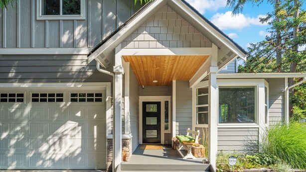 A house with a covered porch, a garage, and a front door.