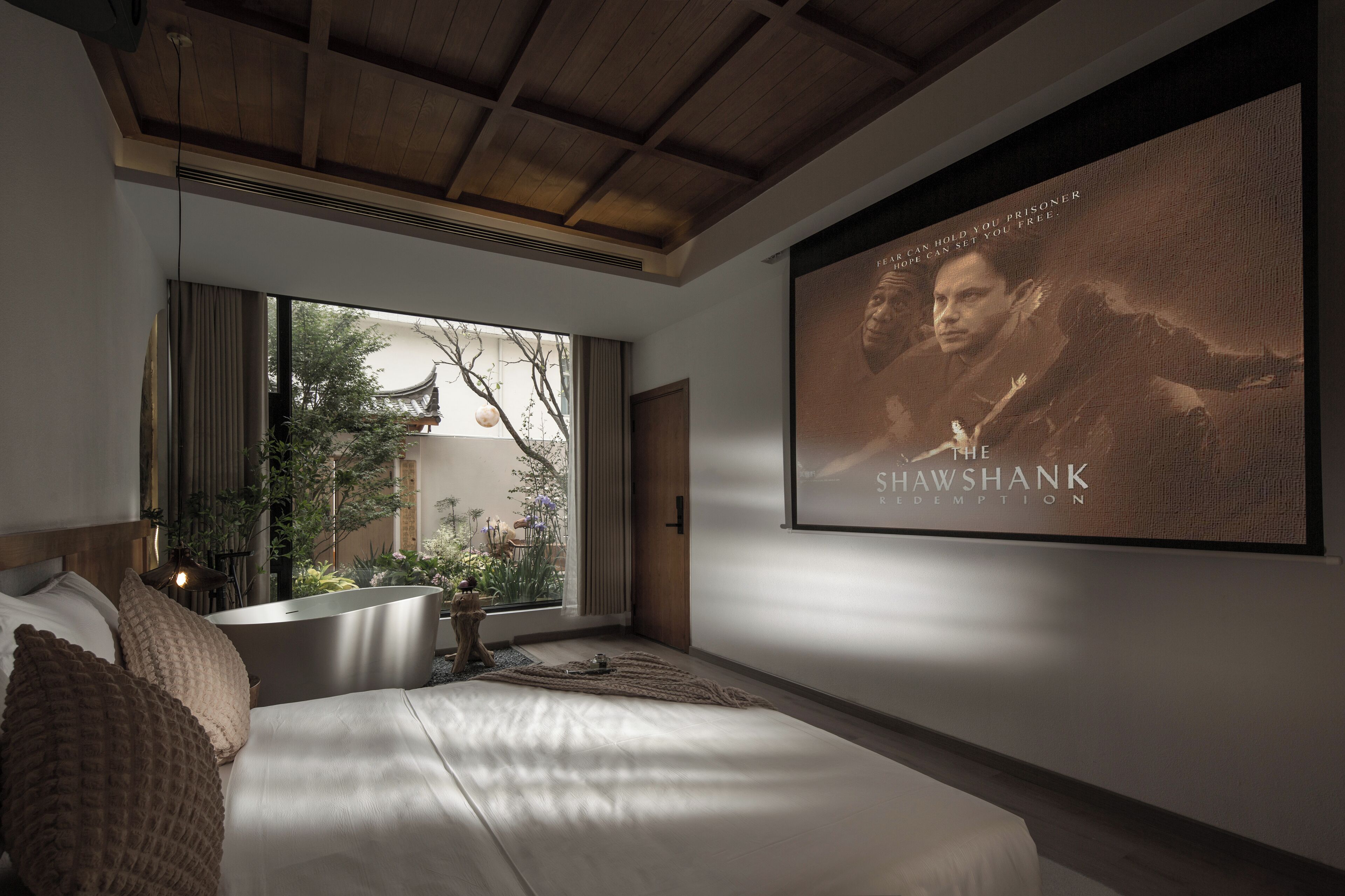 A bedroom with a large bed, a window with a view of a traditional building, and a poster on the wall.