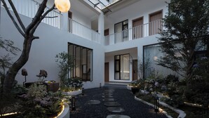 A multi-level courtyard with a central pathway, surrounded by planters and trees. - SIXI Conglu Design Aesthetics Hotel (Lijiang)