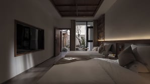 A modern bedroom with a large bed, a TV mounted on the wall, and a view of the outside. - SIXI Conglu Design Aesthetics Hotel (Lijiang)
