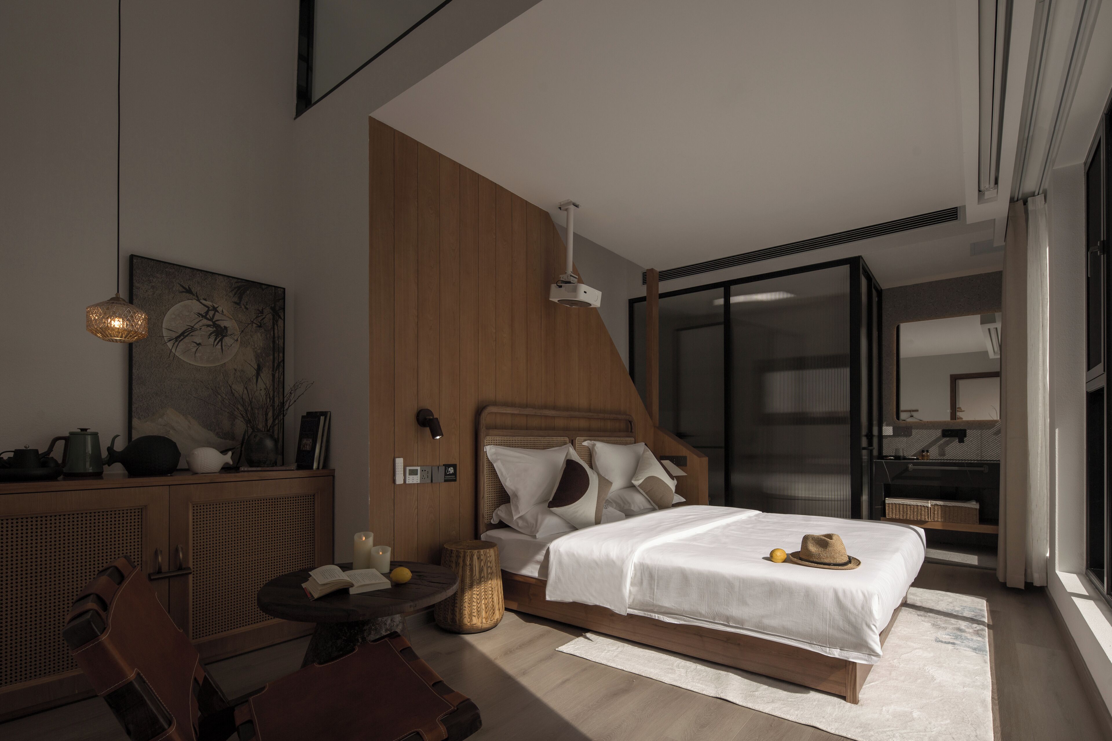 A modern hotel room with a large bed, a desk, and a dining area.