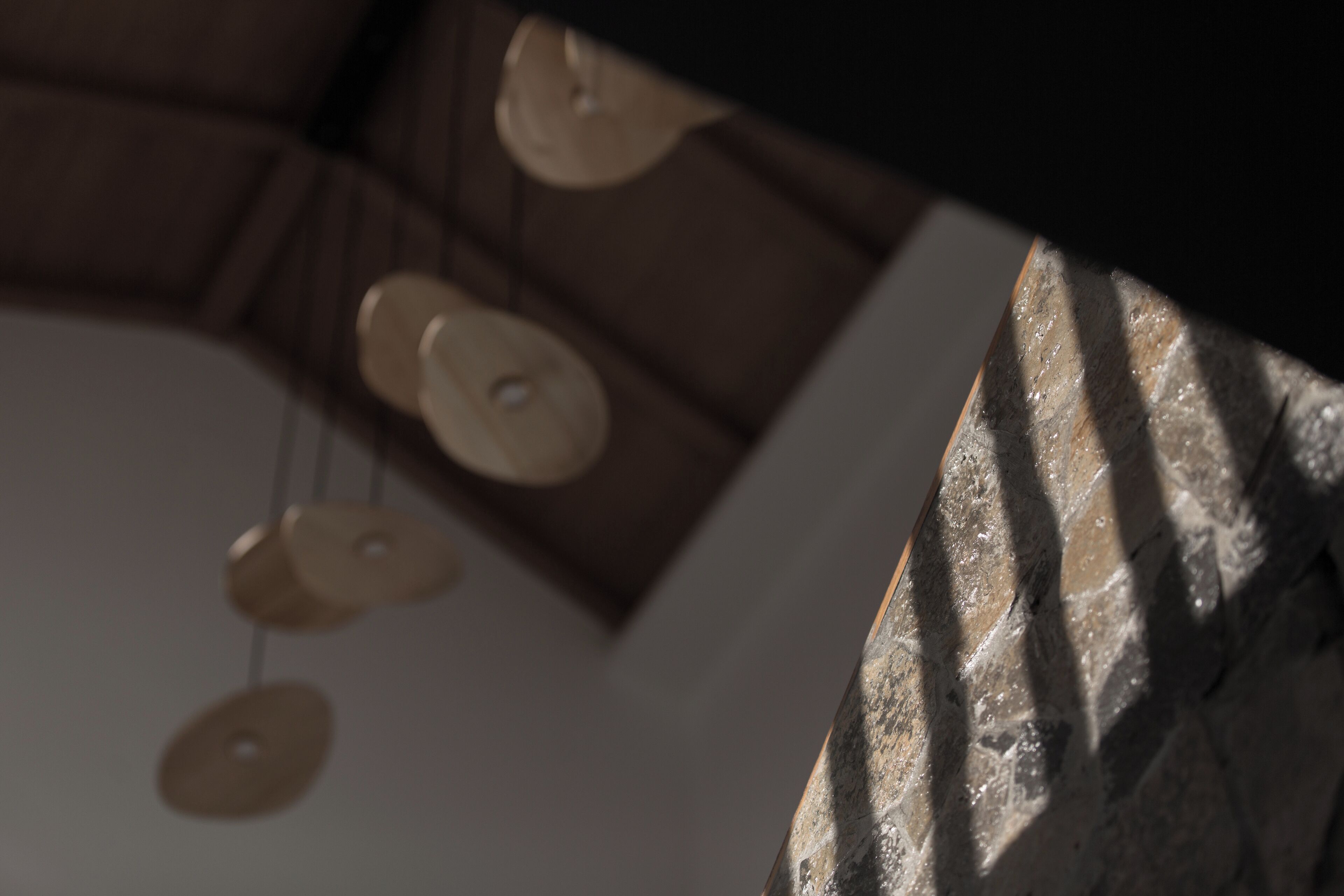 Een detail van een plafond met een uniek, structureel ontwerp en een reeks ronde lampen.