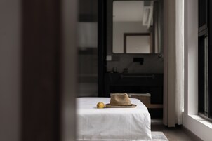 Un dormitorio con una cama, un sombrero y un limón sobre la cama.