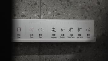 A control panel with icons for stop, front, rear, massage, position, water temperature, seat temperature, and dryer.