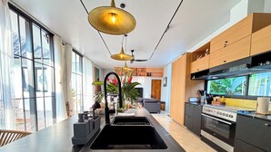 Una cocina moderna con una isla central, armarios negros y un horno empotrado.