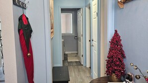 A hallway with a coat rack, a small bench, a Christmas tree, and a table with a tray. - 3-bedroom house in awesome Billings with AC, fitness room (Billings)