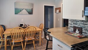 A kitchen with a dining table, chairs, a stove, and a painting on the wall. - 3-bedroom house in awesome Billings with AC, fitness room (Billings)