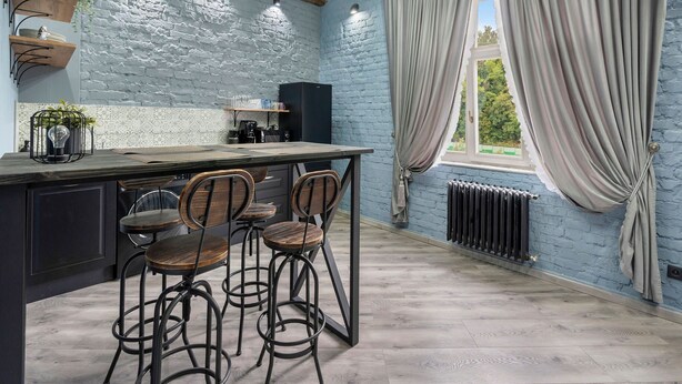 A kitchen with a rustic design, featuring exposed brick walls, wooden beams, and a large window with curtains. - Carlsbad Suites by Interhome (Carlsbad)