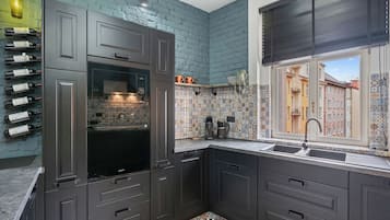 Een koelkast, een magnetron, een oven, kookgerei, borden en bestek