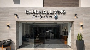 The entrance to Cardinal Living Cabo San Lucas with a modern design, glass doors, and a seating area outside. - Luxury Cabo Studio | Rooftop Pool, Hot Tub & Walk to Beach (Cabo San Lucas)