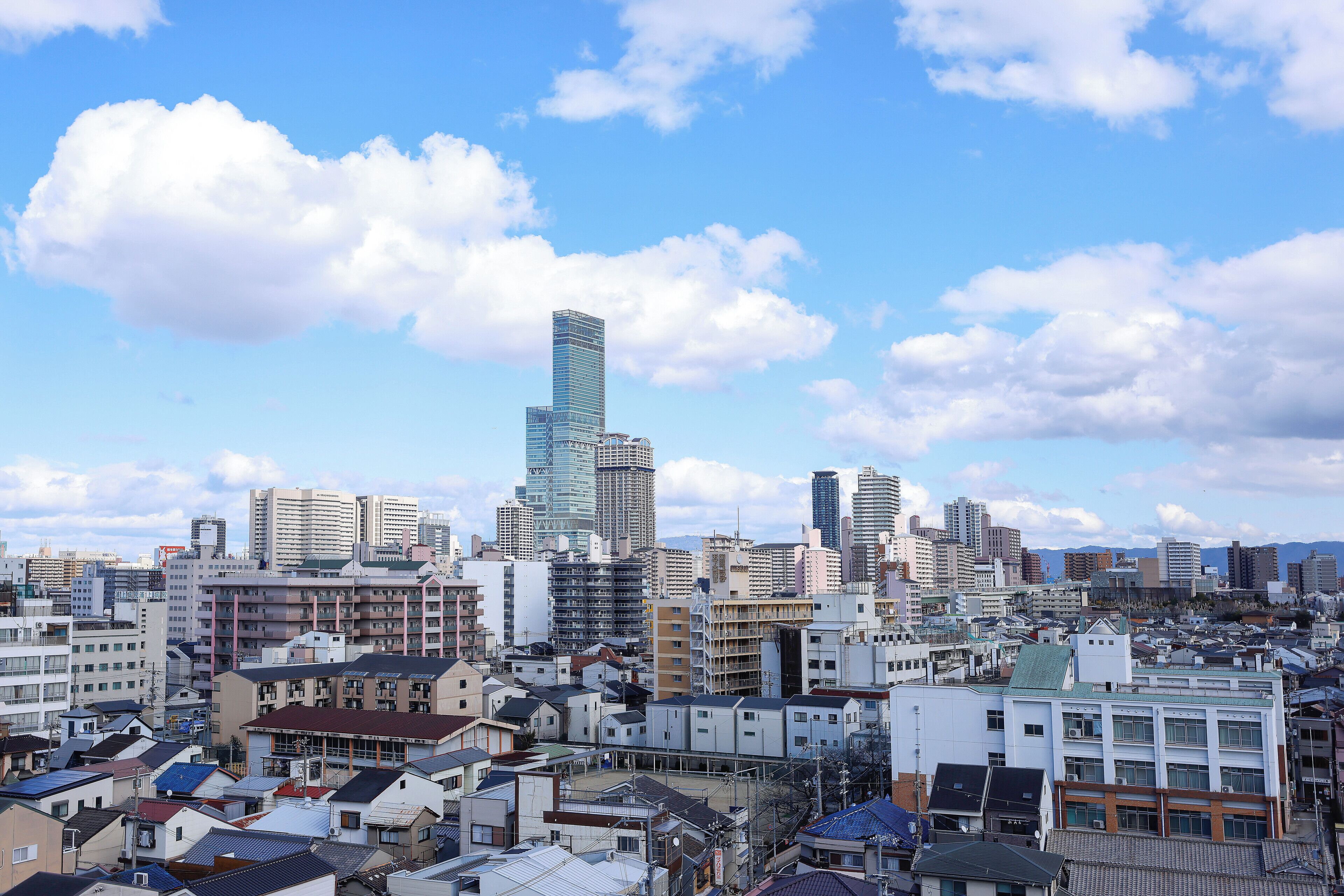 Un paysage urbain caractérisé par un gratte-ciel imposant, des immeubles résidentiels denses et un mélange de bâtiments commerciaux.