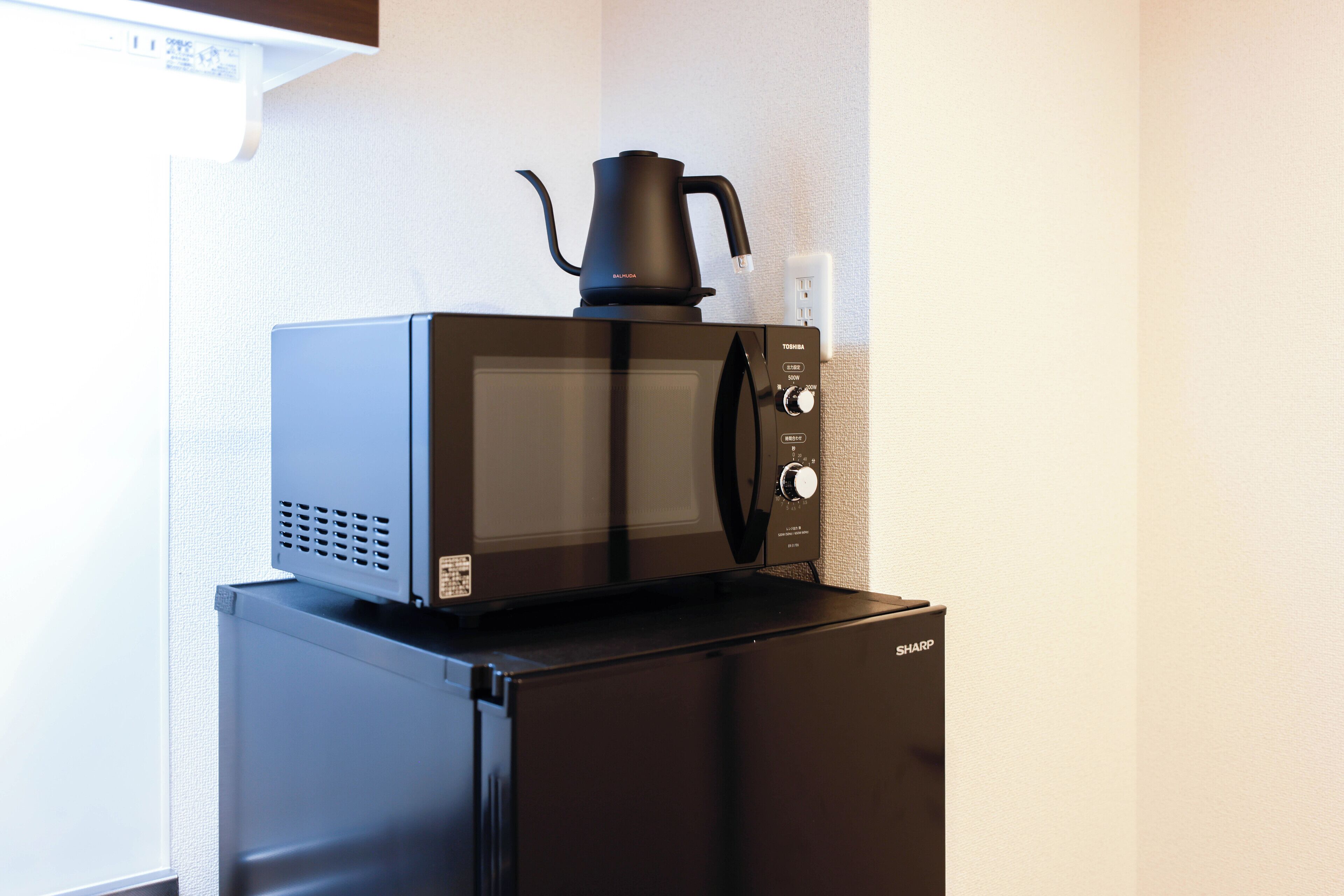 A compact kitchen with a microwave and a refrigerator.