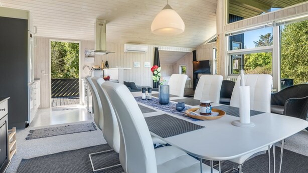 Un intérieur moderne comprenant un coin repas, une cuisine et un espace de vie.