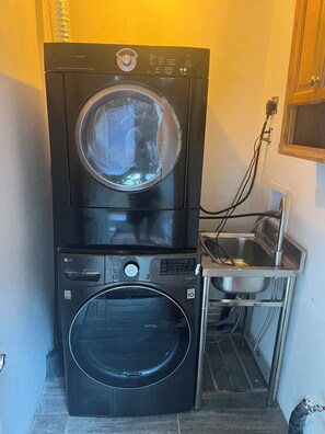 A stacked washer and dryer unit with a direct drive feature, a control panel, and a stainless steel sink. - Cozy 1-bedroom apartment in nice Edmonds with AC and heat (Edmonds)