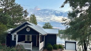 Une maison de plain-pied avec un porche, un garage et une vue sur un lac.