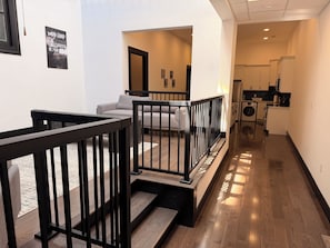 Ein modernes Interieur mit Treppe, einer Couch und Küchenzeile.