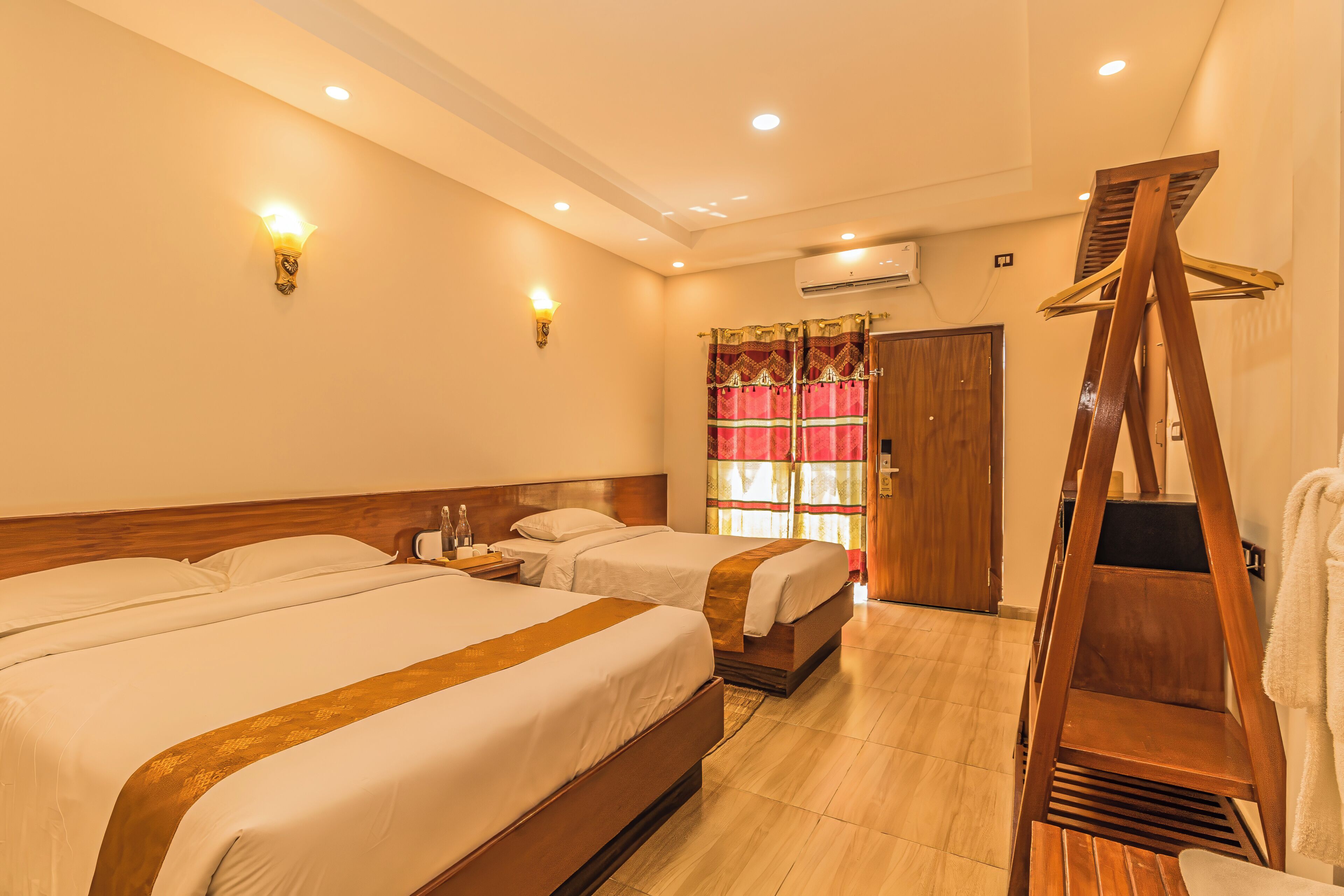 A hotel room with two beds, a wooden ladder, and a shower area.