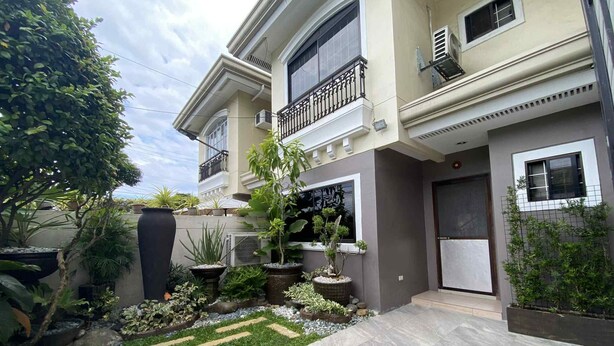A modern two-story house with a balcony, a tiled patio, and various potted plants. - Thereseplace, cozy 3-bedroom house in the heart of Davao City (Davao City)