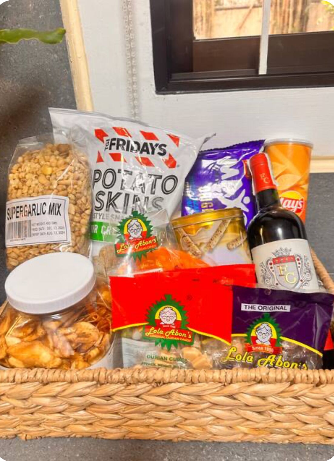 A basket containing various snacks and a bottle of soda.