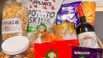 A basket containing various snacks and a bottle of soda.