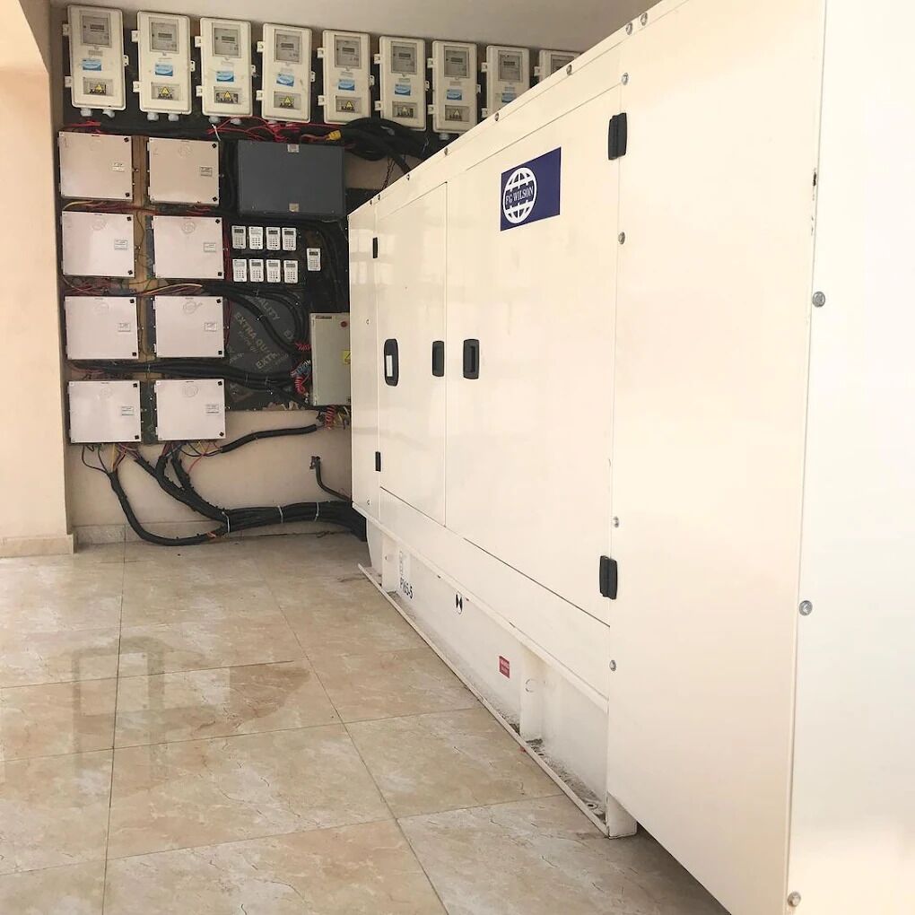 A utility room with electrical panels, control boxes, and wiring.