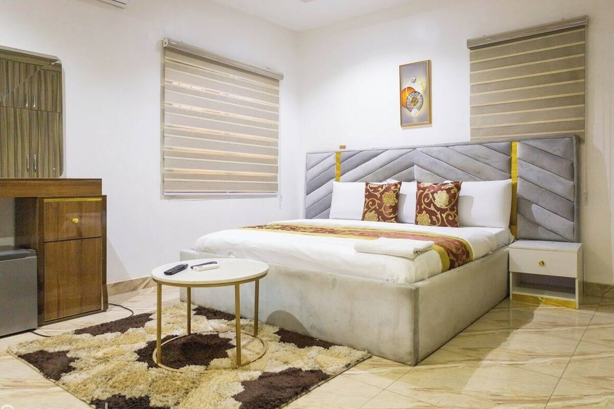 A bedroom with a bed, bedside table, and a small cabinet.