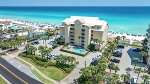 Un hôtel doté d’une piscine, entouré de palmiers et offrant une vue sur la plage.