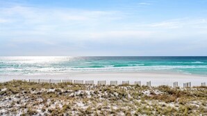 Une plage avec un rivage sablonneux et une clôture en bois au premier plan.