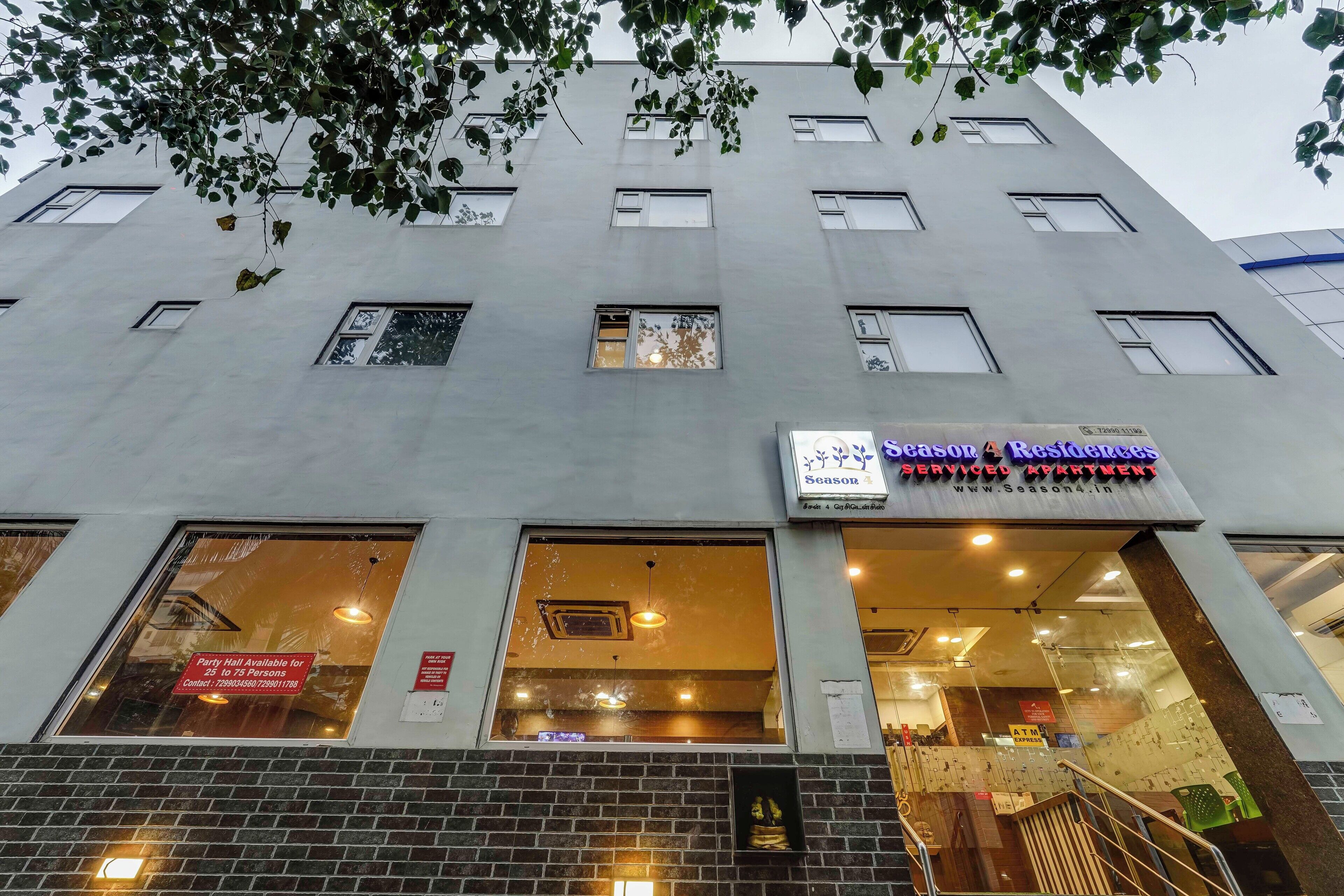 A building with multiple windows and a sign for "Seasonal Residences" service.