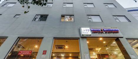 A building with multiple windows and a sign for "Seasonal Residences" service.