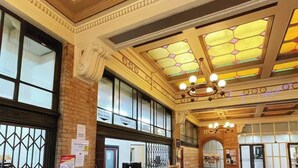 A lobby with a high ceiling, large windows, and a check-in area with signs. - Georgie Accommodation (Auckland)