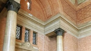 A building entrance with a sign reading "District Offices," large columns, and a dark door. - Georgie Accommodation (Auckland)