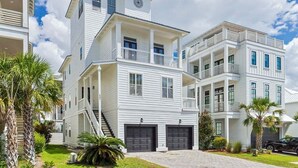 A multi-story residential building with a balcony, a staircase, and a garage.