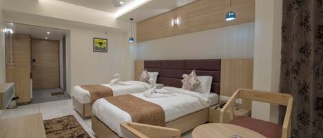 Una habitación de hotel moderna con dos camas, un escritorio, una silla y una mesita.