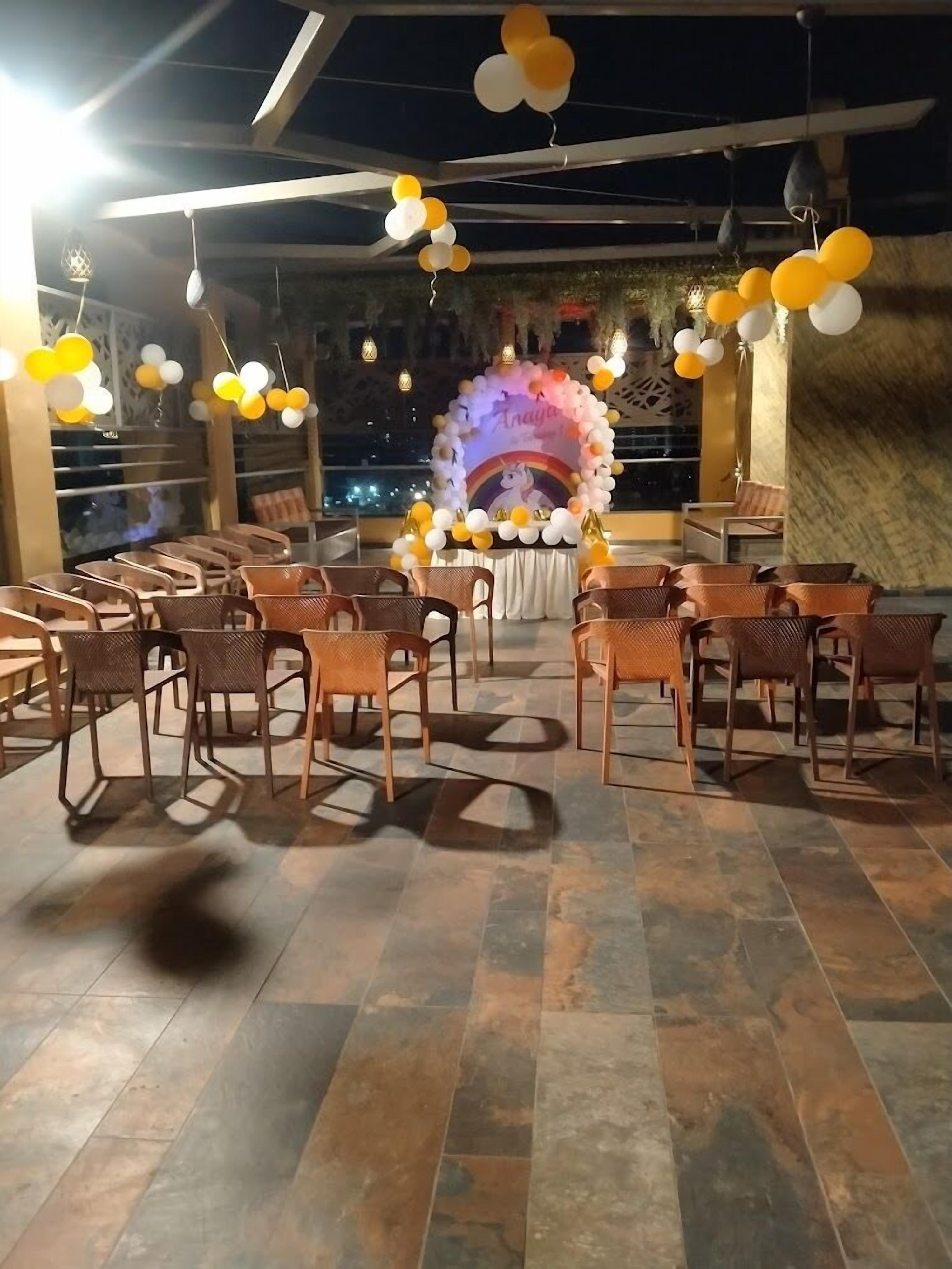 An outdoor event space with a stage, chairs, and a tiled floor.