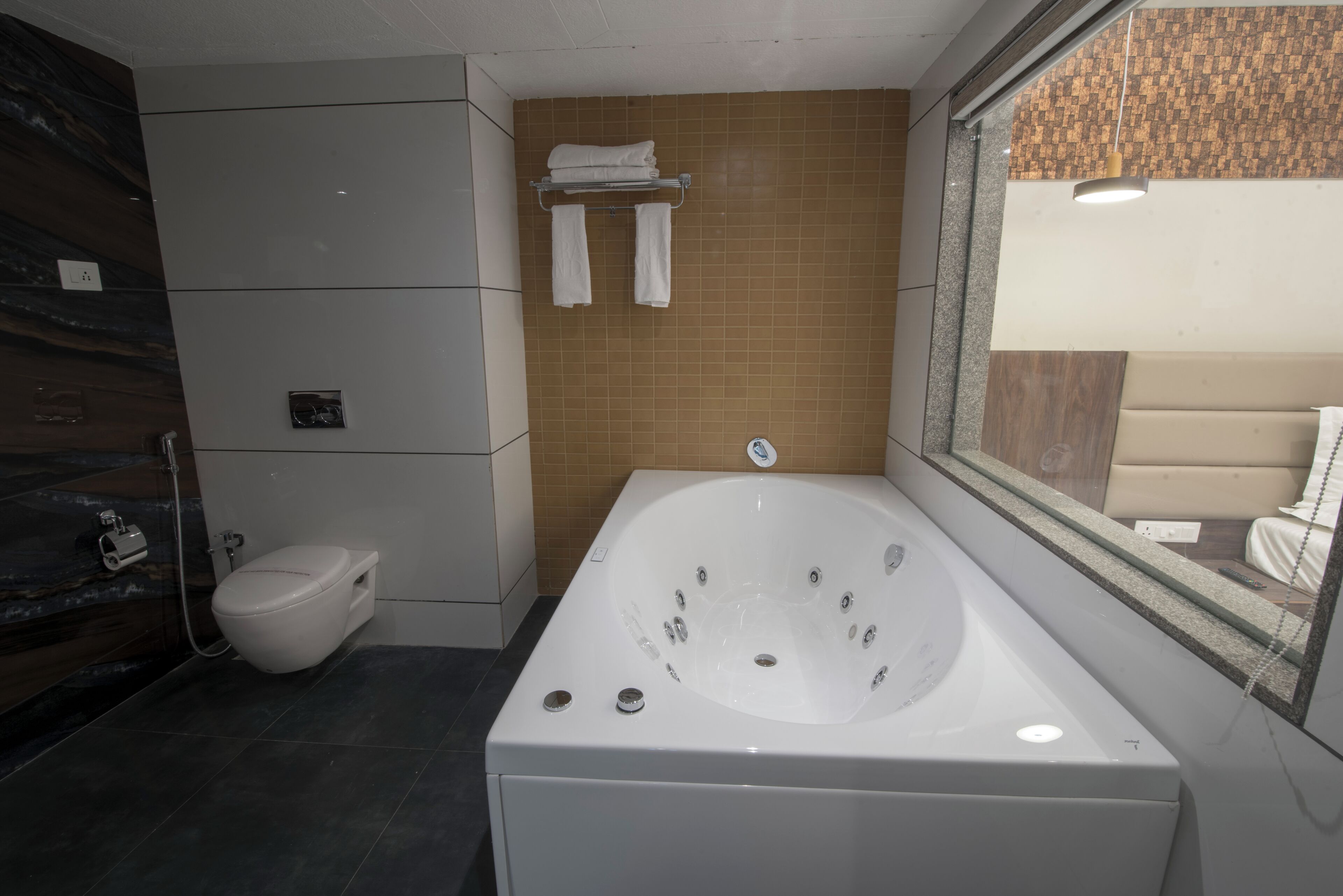 Un baño moderno con una bañera grande, un inodoro y una zona de ducha.